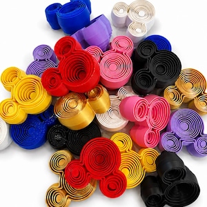 May include: A collection of multi-coloured plastic cookie cutters shaped like mouse heads. The cutters feature concentric circular patterns and come in various colours including red, blue, yellow, black, white, pink, purple, and metallic gold.