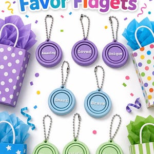 May include: Colorful image of party favors. The image features round, colorful fidget toys with words like "Amazing" and "Loved" on them. The toys are attached to keychains. Gift bags with tissue paper and confetti are also in the image.
