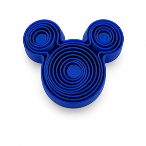 Puede incluir: Un molde de silicona azul brillante con forma de cabeza de rat&oacute;n, que presenta una serie de crestas circulares conc&eacute;ntricas en la base principal y en las dos orejas m&aacute;s peque&ntilde;as, creando una superficie texturizada y escalonada.