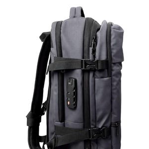 May include: Gray backpack with black straps, zippers, and buckles. Features a combination lock and padded shoulder straps. The bag has multiple compartments and a top handle for carrying. A practical and stylish travel bag.
