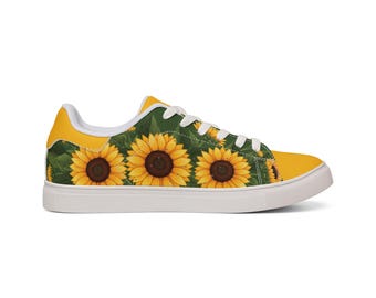 May include: A low-top sneaker featuring a vibrant sunflower pattern against a dark green background. The shoe has a solid yellow heel tab, a matching yellow toe cap, white laces, and a thick white rubber sole, creating a floral design.