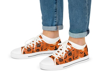 May include: Low-top sneakers featuring an orange canvas upper with a repeating black pattern of jack-o'-lanterns, haunted houses, bats, spiderwebs, and ghosts. The shoes have white laces, white rubber toe caps, and white rubber soles.