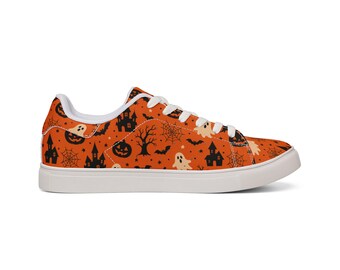 Puede incluir: Una zapatilla baja con parte superior naranja y un patrón repetitivo en negro y crema de casas encantadas, fantasmas, calabazas, murciélagos, telarañas y árboles desnudos. Incluye cordones blancos, forro interior blanco y suela de goma blanca.