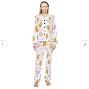 Pu&ograve; includere: Pigiama bianco con motivo a carote e impronte di zampe. La parte superiore a maniche lunghe ha un colletto e bottoni neri. I pantaloni hanno un design abbinato a carote e impronte di zampe. Il pigiama &egrave; realizzato in un materiale morbido e setoso.