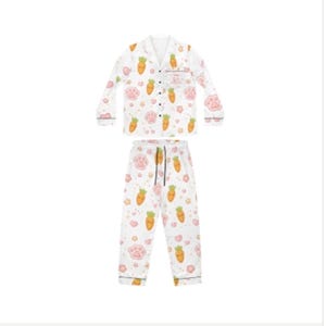 Pu&ograve; includere: Pigiama bianco con motivo a carote e impronte di zampe. La parte superiore a maniche lunghe ha un colletto a revers e una tasca sul petto. I pantaloni hanno un elastico in vita con coulisse. Il bordo &egrave; nero.