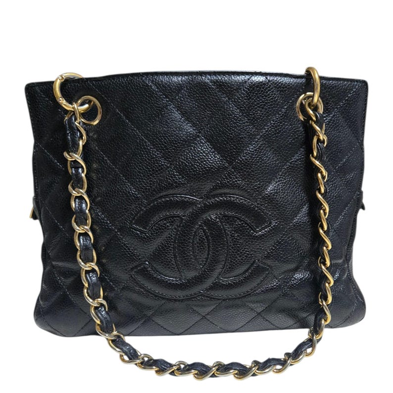 May include: Black quilted leather handbag with gold-tone chain straps. The bag features a diamond pattern and a prominent double-C logo on the front. The bag has a textured finish and a rectangular shape.