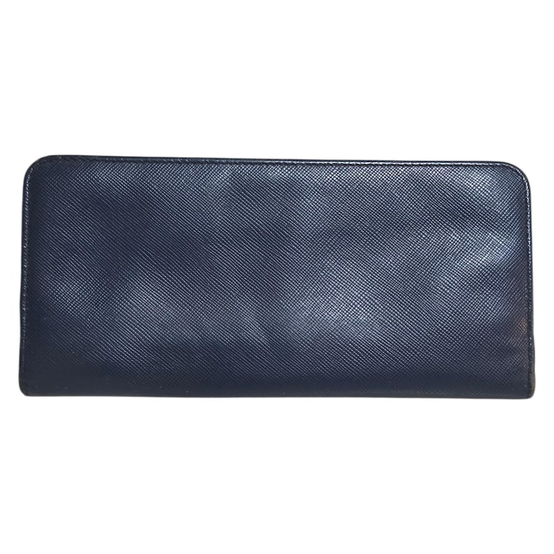 May include: A rectangular, navy blue wallet with a textured surface. The wallet has a zipper closure and a simple, minimalist design. The wallet is made of a durable material.