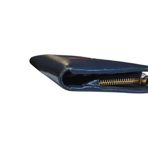 May include: A navy blue leather wallet with a gold zipper. The wallet is closed and the zipper is visible along the edge. The leather has a slight sheen.
