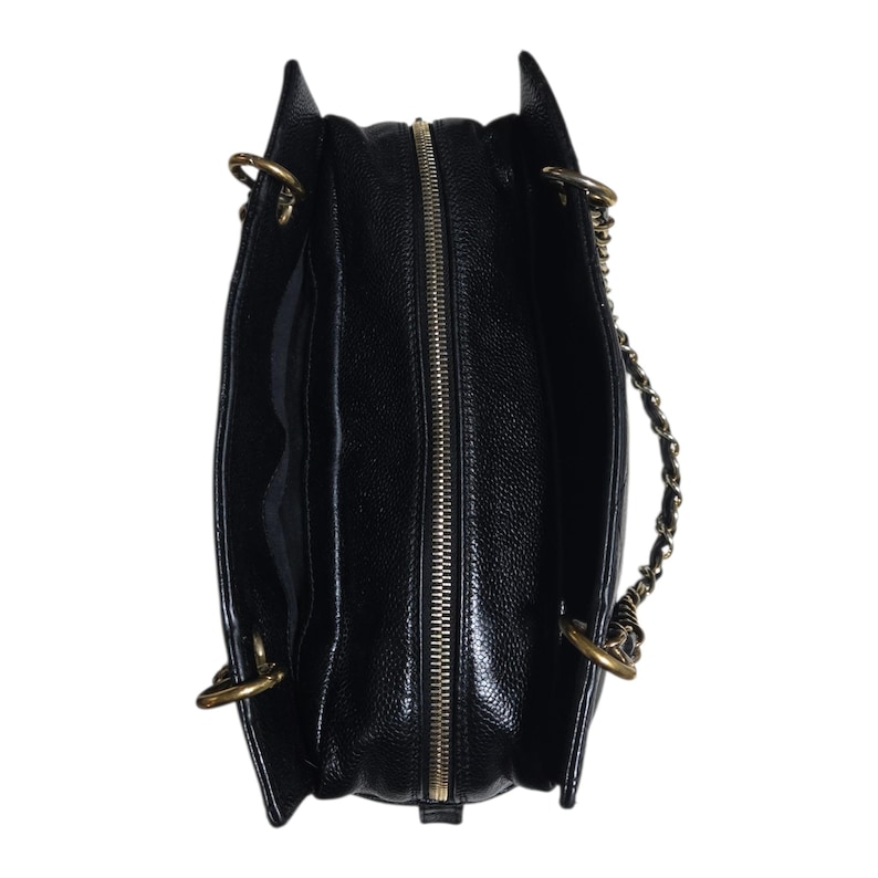 May include: Black leather tote bag with a gold-tone zipper and chain strap. The bag has a textured finish and a structured shape. The interior is black and appears to have multiple compartments. The bag has gold-tone hardware.