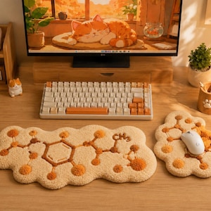 Può includere: Un tappetino per tastiera trapuntato color crema e un tappetino per mouse abbinato con un design a struttura chimica marrone e il testo CH3. Il set è posizionato su una scrivania in legno davanti a un monitor e a una tastiera meccanica.