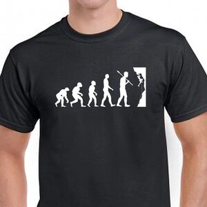 May include: A black short-sleeved t-shirt featuring a white graphic print that depicts the evolution of humanity, starting from a hunched primate and progressing to an upright figure holding a climbing tool, ending with a person rock climbing.