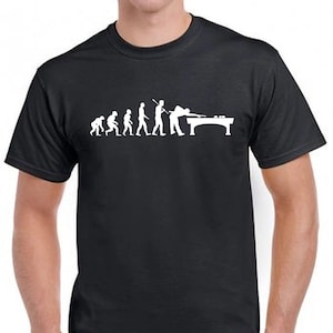 May include: A black short-sleeved t-shirt featuring a white graphic print that depicts the evolution of humanity, starting from a primate and progressing to a person playing billiards at a pool table with a cue stick and balls.