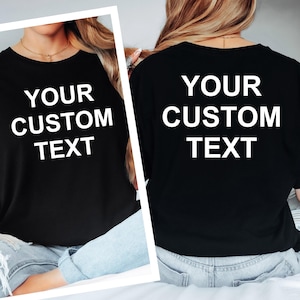 May include: Black crew neck t-shirts with the text "YOUR CUSTOM TEXT" in white block letters. The shirts are displayed from the front and back, showcasing the customizable design. The shirts are worn by a person.