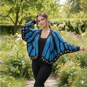 Può includere: Un cardigan a maniche lunghe aperto sul davanti con un motivo ad ali di farfalla blu brillante e nero. Il capo presenta un bordo nero lungo le estremità e una silhouette ampia e fluida che imita la forma delle ali di farfalla.