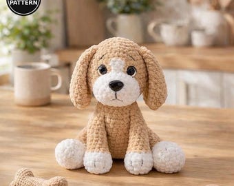 May include: A crochet puppy toy with tan and white yarn, featuring large black eyes, a black nose, and floppy ears. The puppy sits upright with white paws. A small crochet bone and a rope toy with a ball are placed in front of the puppy. PDF PATTERN.