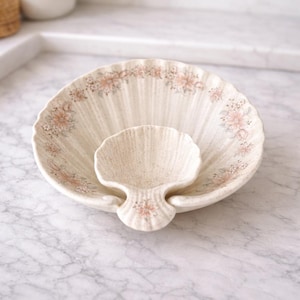 May include: A white ceramic mug with a black handle and the text "But First, Coffee" in a black, bold font. The mug is on a white surface. The mug is approximately 4 inches tall.