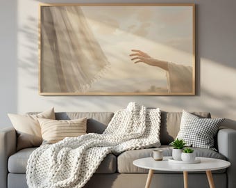 Peut inclure: Une impression d'art rectangulaire dans un cadre en bois clair représentant une main tendue vers un rideau en tissu transparent et fluide sur un ciel aux tons dorés. L'œuvre est exposée au-dessus d'un canapé gris avec un plaid en tricot blanc.