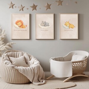May include: Three rectangular wall art prints in light wood frames featuring watercolor illustrations of a sleeping lion, a hippo, and a giraffe, each resting on a pillow with the text Du er sterk og modig, Du er elsket, and Du er dyrebar.
