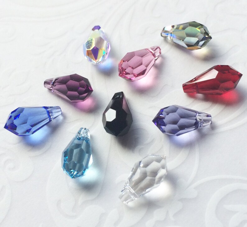 May include: Assortment of ten teardrop-shaped crystal pendants in various colors, including clear, blue, purple, pink, red, and black.