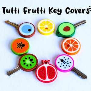 May include: A collection of key covers with fruit designs, including a lemon, kiwi, and orange. The key covers are colorful and feature the text "Tutti Frutti Key Covers". Some designs may require a small amount of glue for final assembly.