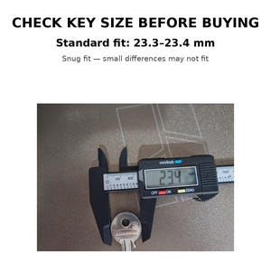 May include: A digital caliper measuring a key, displaying 23.4 mm. The text above reads "CHECK KEY SIZE BEFORE BUYING" and specifies a standard fit of 23.3-23.4 mm. The key is silver and the caliper is black.