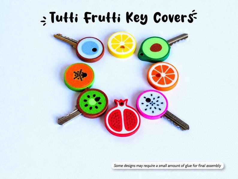 May include: A collection of key covers with fruit designs, including a lemon, kiwi, and orange. The key covers are colorful and round, with the text "Tutti Frutti Key Covers" at the top. Some designs may require a small amount of glue for final assembly.