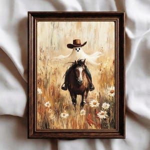 Könnte beinhalten: Ein gerahmtes Ölgemälde zeigt einen weißen Geist mit braunem Cowboyhut auf einem braunen Pferd in einem Feld aus hohem goldenem Gras und weißen Gänseblümchen. Das Kunstwerk befindet sich in einem dunkelbraunen Holzrahmen mit Struktur.