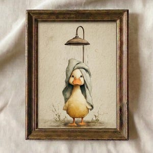 May include: Watercolor print of a yellow duck taking a shower, framed in a brown wooden frame. The duck is wearing a blue towel on its head, with a shower head above. The artwork has a vintage, whimsical feel.