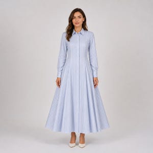 May include: A floor-length shirt dress featuring a light blue and white vertical striped pattern. The garment has a classic collar, long sleeves with buttoned cuffs, a button-down front placket, and a fitted waist that flares into a full skirt.
