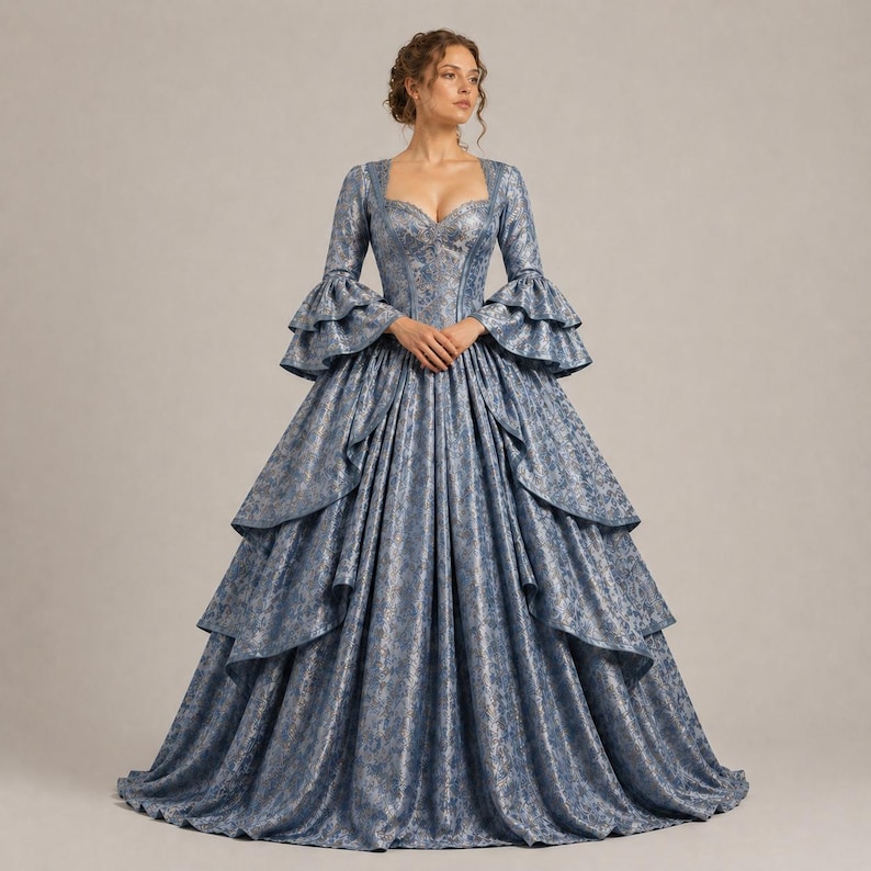 K&ouml;nnte beinhalten: Ein blau-silbernes Ballkleid mit Muster, langen &Auml;rmeln und ger&uuml;schten Manschetten. Das Kleid hat einen herzf&ouml;rmigen Ausschnitt und einen mehrschichtigen Rock. Das Kleid ist bodenlang und hat ein eng anliegendes Oberteil.