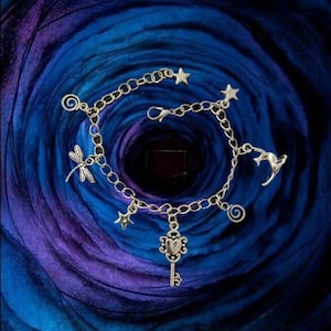 Coraline inspired silver charm bracelet with adjustable length.