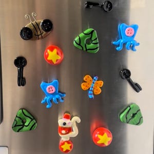 May include: A white ceramic mug with a black handle and the text "But First, Coffee" in a handwritten style. The mug is on a white surface. The mug is approximately 4 inches tall.