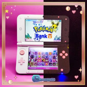 May include: A dual-toned handheld gaming console featuring a white left side and a black right side. The top screen displays the Pokémon Bank logo with various character illustrations, while the bottom touch screen shows a grid of game icons.
