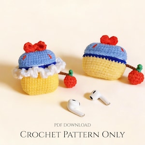 May include: Two handmade crochet earbud cases in a Snow White design, featuring yellow, blue, and white yarn. Each case has a red bow and a red apple accent. White earbuds are placed near the cases. The text "CROCHET PATTERN ONLY" is at the bottom.