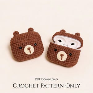 Peut inclure: Deux étuis marron en crochet en forme d'ours pour écouteurs sans fil. Un étui est fermé, l'autre ouvert, révélant des écouteurs blancs. Chaque étui a un museau crème et des yeux noirs. Le texte "CROCHET PATTERN ONLY" est en bas.
