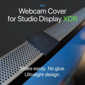 May include: A webcam cover for Studio Display XDR. The cover is black and silver, with the text "Slides easily. No glue. Ultralight design." The cover is designed to slide easily onto the display.