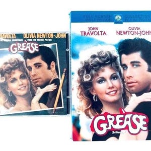 Può includere: Una custodia per CD della colonna sonora di Grease e una custodia per DVD di Grease con John Travolta e Olivia Newton-John. La custodia del CD include una matita appoggiata in diagonale sulla copertina. Entrambi gli articoli mostrano il titolo.