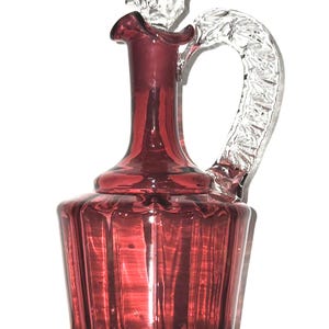 Antique Victorian Cranberry Glass Claret Jug with Cap. Hand Blown Glass with a deep Ruby Red Color and a clear handle from the late 1800s