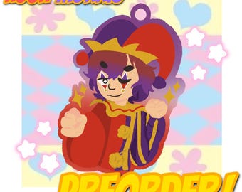 Puede incluir: Ilustración de un personaje de bufón con un atuendo rojo y morado con una corona y detalles dorados. La imagen incluye el texto "HUGH MORRIS" y "PREORDER!" en amarillo, junto con estrellas y corazones decorativos.
