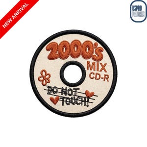May include: A circular embroidered patch featuring a cream-colored background with a black border. The text 2000's MIX CD-R is stitched in orange and black. It includes a small orange flower, two orange hearts, and the text DO NOT TOUCH!