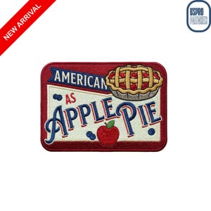 May include: Embroidered patch with a red border and the words "AMERICAN AS APPLE PIE." The design includes a slice of apple pie, a red apple, and blueberries. The patch has a white background with blue and red accents.