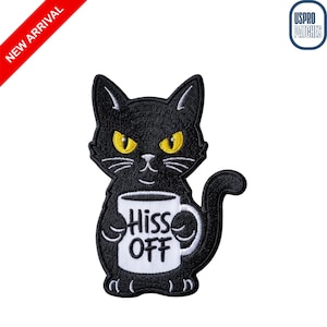 May include: Black cat patch with yellow eyes holding a white mug with the words "Hiss Off". The patch has a curved tail and is outlined in black. A red banner in the upper left corner reads "NEW ARRIVAL".