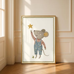 May include: A framed art print featuring a cartoon mouse reaching for a golden star. The mouse wears a red and white striped shirt and blue overalls with star patterns. The artwork has a gold frame and a cream-colored background.