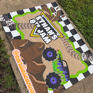 Könnte beinhalten: Ein rechteckiges Schild mit schwarz-weißem Schachbrettmuster am Rand, einem braunen, schlammartigen Hintergrund mit Reifenspuren und einem grünen und violetten Monstertruck. Der Text lautet Ethan's 8th Jam in weißen Buchstaben mit gelbem Rand und @carliescanvas.