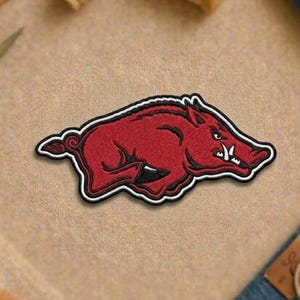 May include: A white ceramic mug with a black handle and the text "But First, Coffee" in a bold, black font. The mug is set against a blurred background, highlighting its clean design.