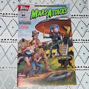 May include: A vintage Topps Comics "Mars Attacks" comic book. The cover features a retro sci-fi illustration of an alien with a large brain, a UFO, and humans with guns. The comic includes the text "We Come in Peace!"