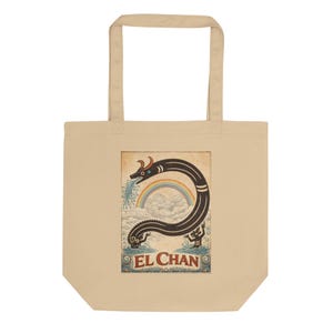 May include: Beige tote bag featuring a colorful illustration of a serpent-like creature with a rainbow and the text "EL CHAN". The artwork is in a vintage style, with the serpent spewing water. The bag has two handles.