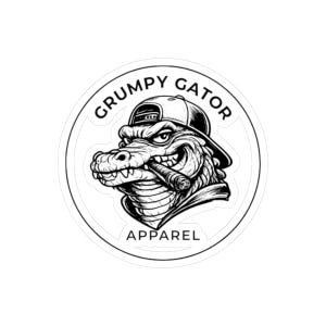 May include: Black and white sticker featuring a cartoon alligator wearing a backwards baseball cap and smoking a cigar. The text "GRUMPY GATOR" arcs above the alligator, with "APPAREL" below, all within a circular border.