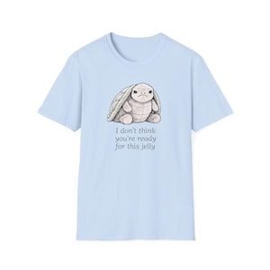 Op de afbeelding: Lichtblauw T-shirt met een cartoonkonijn met een verdrietige uitdrukking. Het konijn is lichtgrijs. De tekst "I don't think you're ready for this jelly" staat eronder.