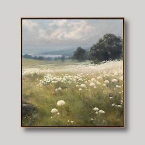 Puede incluir: Pintura de paisaje enmarcada que representa un campo de flores silvestres blancas en un prado. La obra de arte presenta una paleta de colores suaves de verdes, amarillos y azules, con un cielo nublado y árboles distantes. La pintura está en un marco dorado.